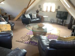 a living room with couches and a glass table at The Oak Lodge, Clematis Cottages, Stamford in Stamford