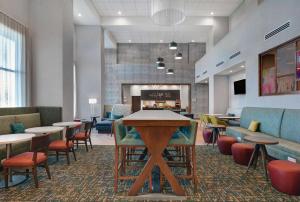 a lobby with tables and chairs and a bar at Hampton Inn & Suites Middleburg, Fl in Middleburg
