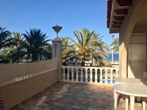 a balcony with a white fence and palm trees at Bungalow en Arenales del Sol in Arenales del Sol