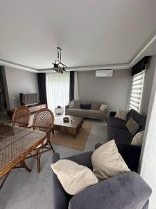 ein Wohnzimmer mit einem Sofa und einem Tisch in der Unterkunft Luxurious Villa in the Heart of Göcek in Fethiye