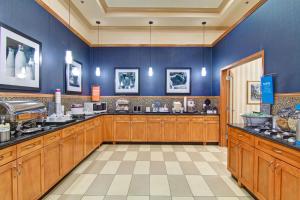 cocina grande con armarios de madera y paredes azules en Hampton Inn by Hilton Kamloops, en Kamloops