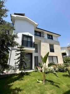 ein weißes Haus mit einer Palme davor in der Unterkunft Luxurious Villa in the Heart of Göcek in Fethiye