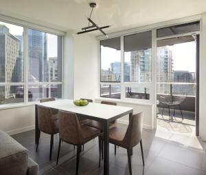 a dining room with a table and chairs and windows at Level Seattle Downtown South Lake Union in Seattle