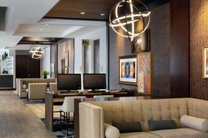 a lobby with a couch and a desk with two monitors at Doubletree By Hilton Jamestown, Ny in Jamestown