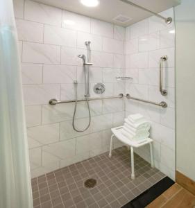 a bathroom with a shower with a bench in it at Doubletree By Hilton Jamestown, Ny in Jamestown