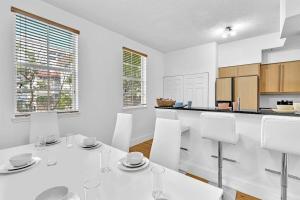 a white kitchen with a white table and chairs at Gorgeous Townhouse Beach Access Resort Amenities in Hallandale Beach