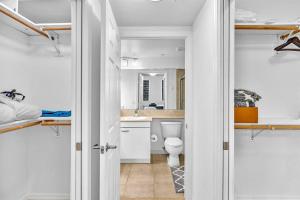 a white bathroom with a toilet and a sink at Gorgeous Townhouse Beach Access Resort Amenities in Hallandale Beach