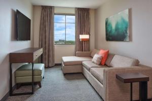 ein Wohnzimmer mit einem Sofa und einem Schreibtisch in einem Hotelzimmer in der Unterkunft Embassy Suites By Hilton Oahu Kapolei - FREE Breakfast in Kapolei