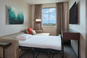 a hotel room with a bed and a couch and a window at Embassy Suites By Hilton Oahu Kapolei - FREE Breakfast in Kapolei