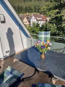 a vase of flowers on a table on a balcony at Ferienwohnung an der Murg in Baiersbronn