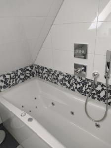a white bath tub with a shower in a bathroom at Ferienwohnung an der Murg in Baiersbronn