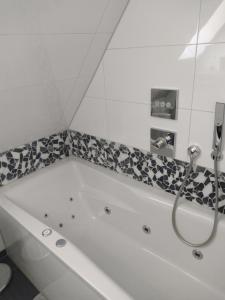 e bagno con vasca bianca e doccia. di Ferienwohnung an der Murg a Baiersbronn Altre 9 foto