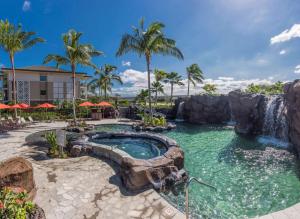 einen Pool mit Wasserfall in einem Resort in der Unterkunft Hilton Grand Vacations Club Kings Land Waikoloa in Waikoloa