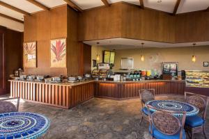 un ristorante con tavoli, sedie e bancone di Hilton Grand Vacations Club Kings Land Waikoloa a Waikoloa