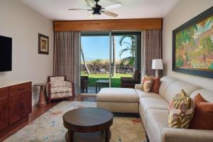 sala de estar con sofá y TV en Hilton Grand Vacations Club Kings Land Waikoloa, en Waikoloa