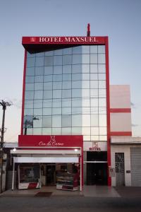 a building with a sign on top of it at Hotel Maxsuel in Cachoeirinha