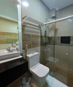 a bathroom with a toilet and a shower and a sink at Hotel Maxsuel 