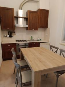 uma cozinha com uma mesa de madeira e algumas cadeiras em La Casa sull'argine 2 em Sarzana