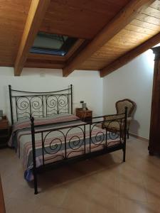 uma cama preta num quarto com tecto em madeira em La Casa sull'argine 2 em Sarzana