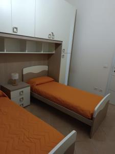 um quarto com duas camas e um armário e uma mesa de cabeceira em La Casa sull'argine 2 em Sarzana