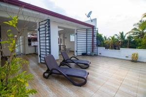 a patio with two chairs sitting on top of a house at Stylish 4BR+3.5BA home wt AC + Rooftop + Parking in Moratuwa
