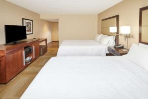 a hotel room with two beds and a flat screen tv at Hampton Inn Lafayette in Lafayette