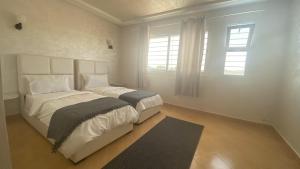 a white bedroom with a large bed and a window at Chambres d hotes Villa 