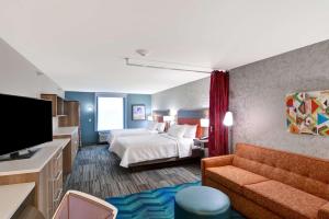 Habitación de hotel con cama y sofá en Home2 Suites By Hilton Lafayette, en Lafayette