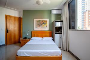 a bedroom with a bed and a window at Savassinho Hotel & Residence in Belo Horizonte