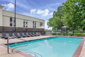 a swimming pool with lounge chairs in front of a building at Hampton Inn Lagrange near Callaway Gardens in La Grange