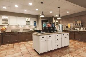una gran cocina con armarios marrones y una isla blanca en Homewood Suites by Hilton La Quinta, en La Quinta