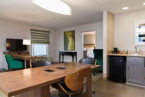 a living room with a dining room table and chairs at Hampton Inn & Suites East Lansing in Okemos