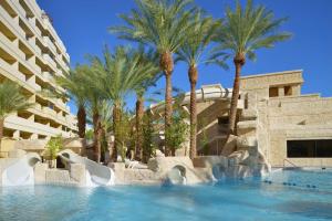 a resort pool with palm trees and a slide at Hilton Vacation Club Cancun Resort Las Vegas in Las Vegas