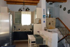 Il comprend une cuisine équipée d'un réfrigérateur et d'une table. dans l'établissement Aretousa Residence in Naoussa, Paros, à Náoussa