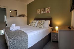ニースにあるEmerald House - TV in every bedroom!の大きな白いベッドとテーブルのある寝室