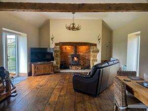 a living room with a couch and a fireplace at The Udderhouse - Udderly Unforgettable Retreat in Donyatt