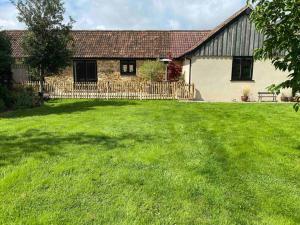 uma casa com um grande relvado em frente em The Udderhouse - Udderly Unforgettable Retreat em Donyatt