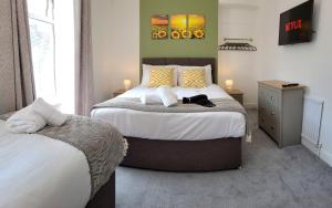 een slaapkamer met een bed met een kat erop bij Emerald House - TV in every bedroom! in Neath