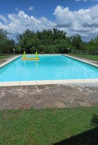 a large blue swimming pool with two yellow slides at Villa Poggio al Sole Bio Agriturismo private pool in San Rocco a Pilli