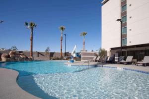 拉斯維加斯的住宿－拉斯維加斯市中心希爾頓惠庭套房酒店，一座游泳池,位于酒店,设有椅子和棕榈树