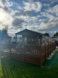 a wooden deck with a gazebo on the grass at The Luxury break Sleeps 6 at 44 Kingfisher Court South facing in Tattershall