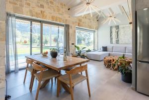 cocina y sala de estar con mesa de madera y sillas en Villa Ersi, en Katelios