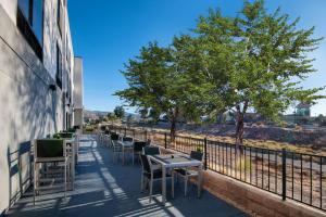 une rangée de tables et de chaises sur le côté d'un bâtiment dans l'établissement Hampton Inn & Suites Las Vegas-Henderson, à Las Vegas