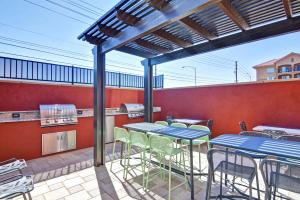 eine Terrasse mit Tischen und Stühlen sowie eine Küche in der Unterkunft Home2 Suites By Hilton Las Vegas Strip South in Las Vegas