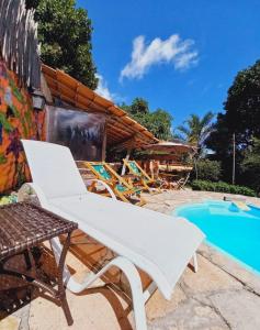 einen weißen Sessel neben dem Pool in der Unterkunft Recanto Villa São João in Palmeiras