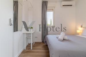 a white bedroom with two beds and a desk at AYZ Joaquín Pol - Auto check-in property in Madrid