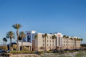 a large building with palm trees in front of it at Hampton Inn & Suites Las Vegas-Red Rock/Summerlin in Las Vegas
