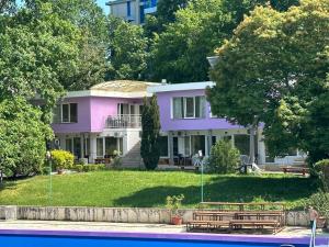 a purple house with benches in front of it at Hotel RIVA in Golden Sands