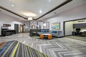 Hampton Inn & Suites Los Angeles Burbank Airport في بربانك: لوبي مكتب مع أريكة وطاولة