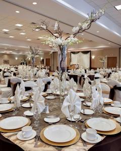a banquet hall with tables with white plates and napkins at Embassy Suites by Hilton Anaheim South in Anaheim